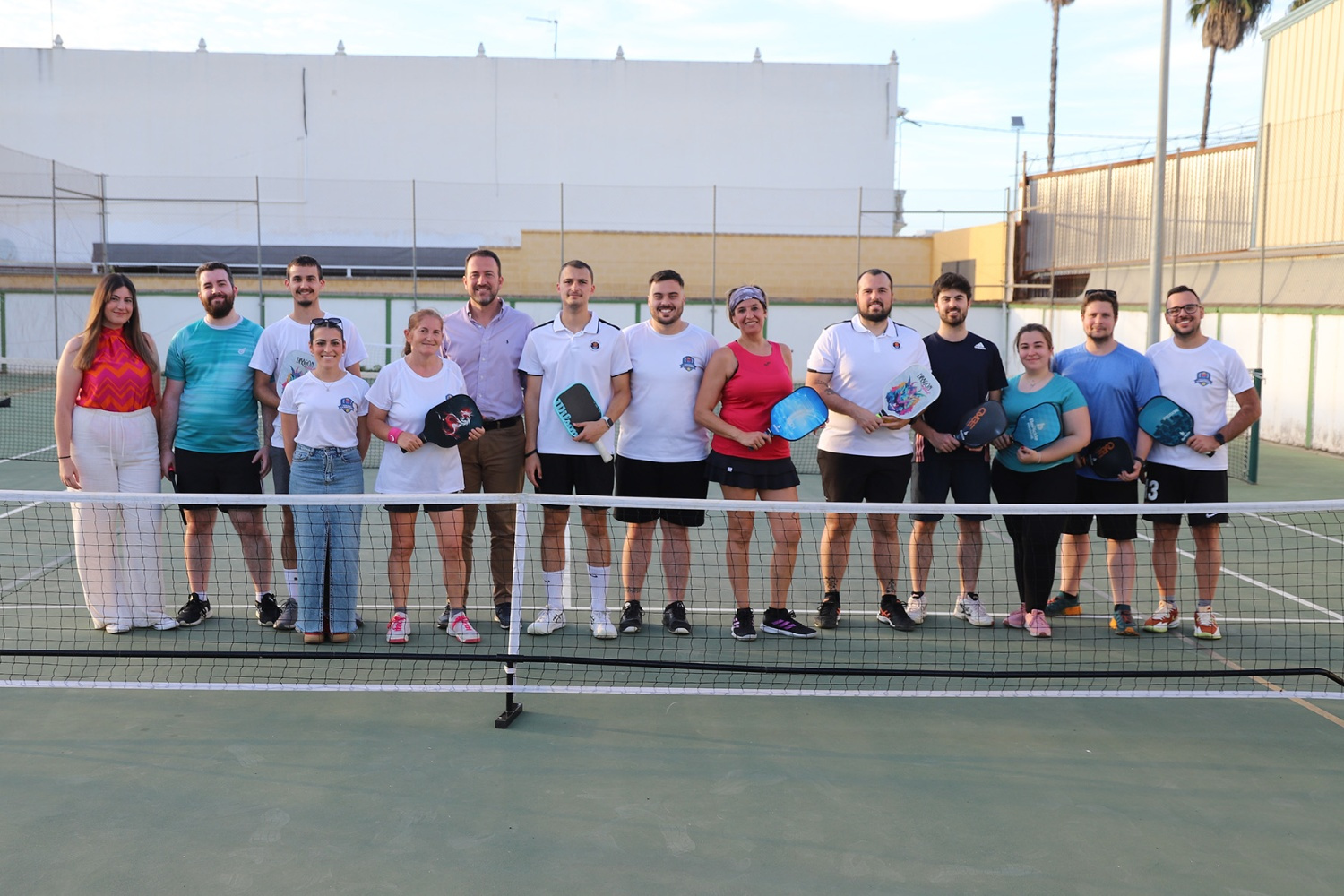 El grupo de Pickleball La Rinconada, con sus palas junto a la red